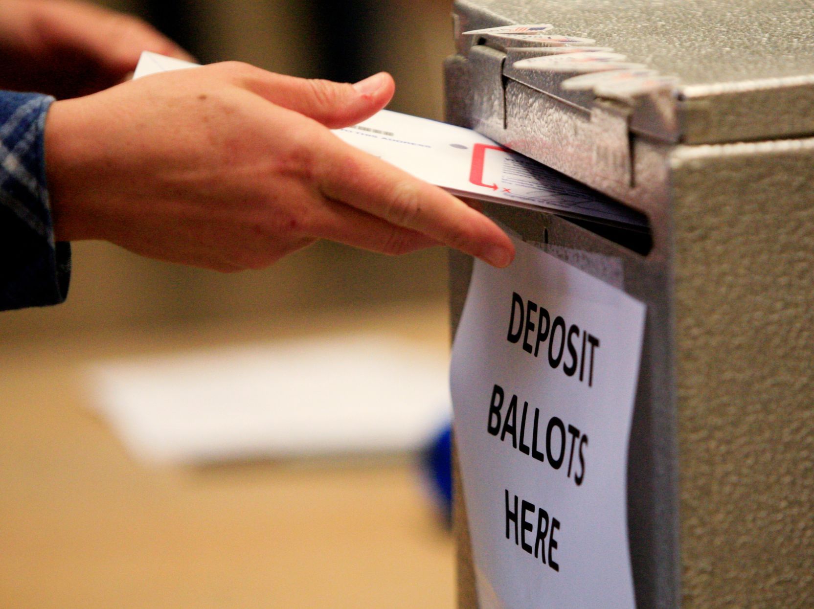 A voter deposits their ballot